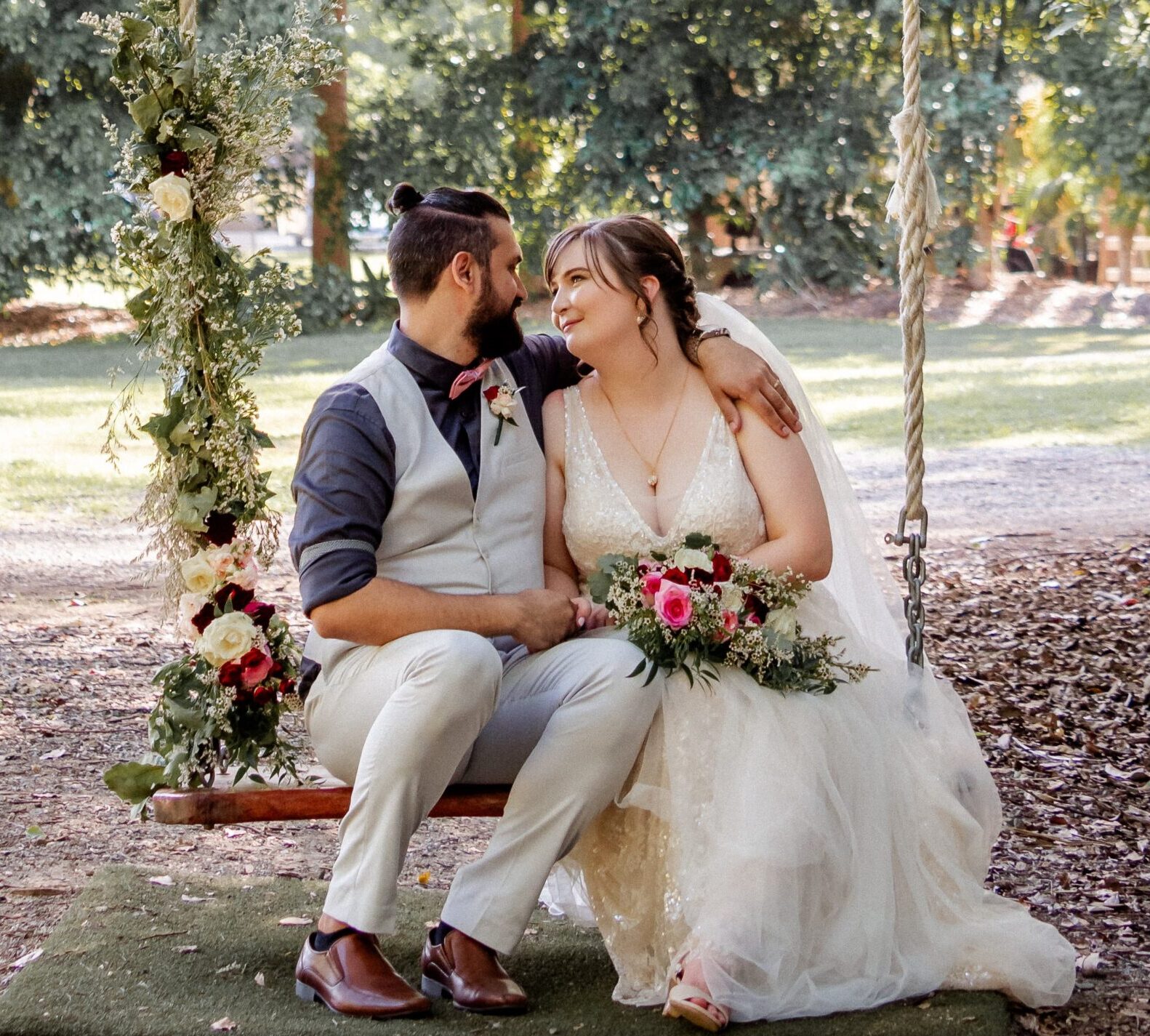 Bride and groom on a garden swing with soft bridal styling